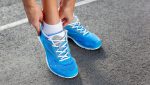 Closeup of Young Woman Tying Sports Shoe