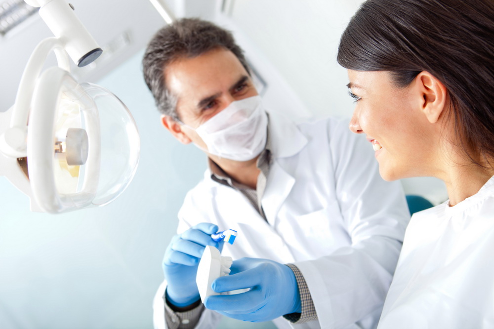 Dentist showing how to brush teeth